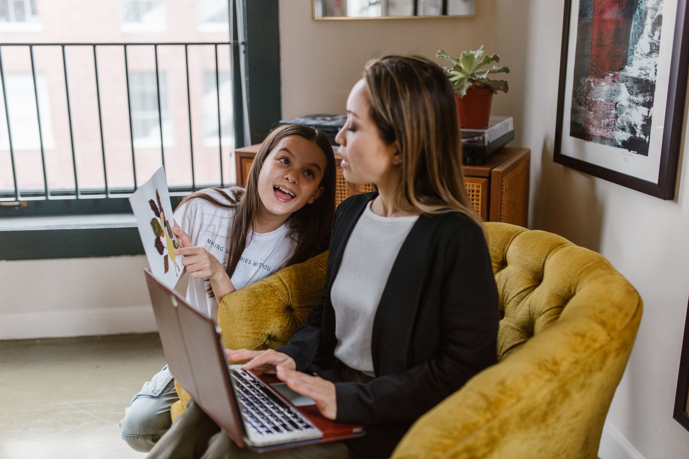 Illustrative stock: a mother at a laptop with her daughter